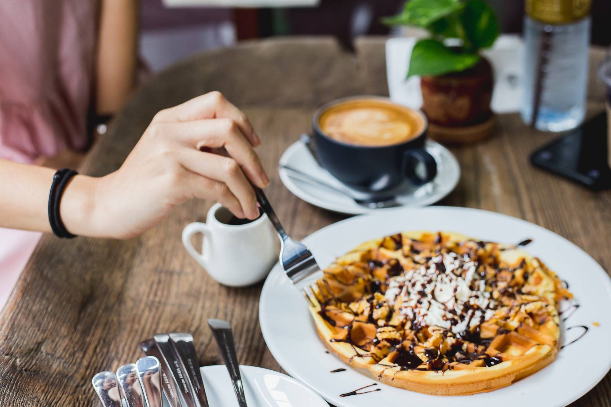 Women are eating waffle in coffee shop.