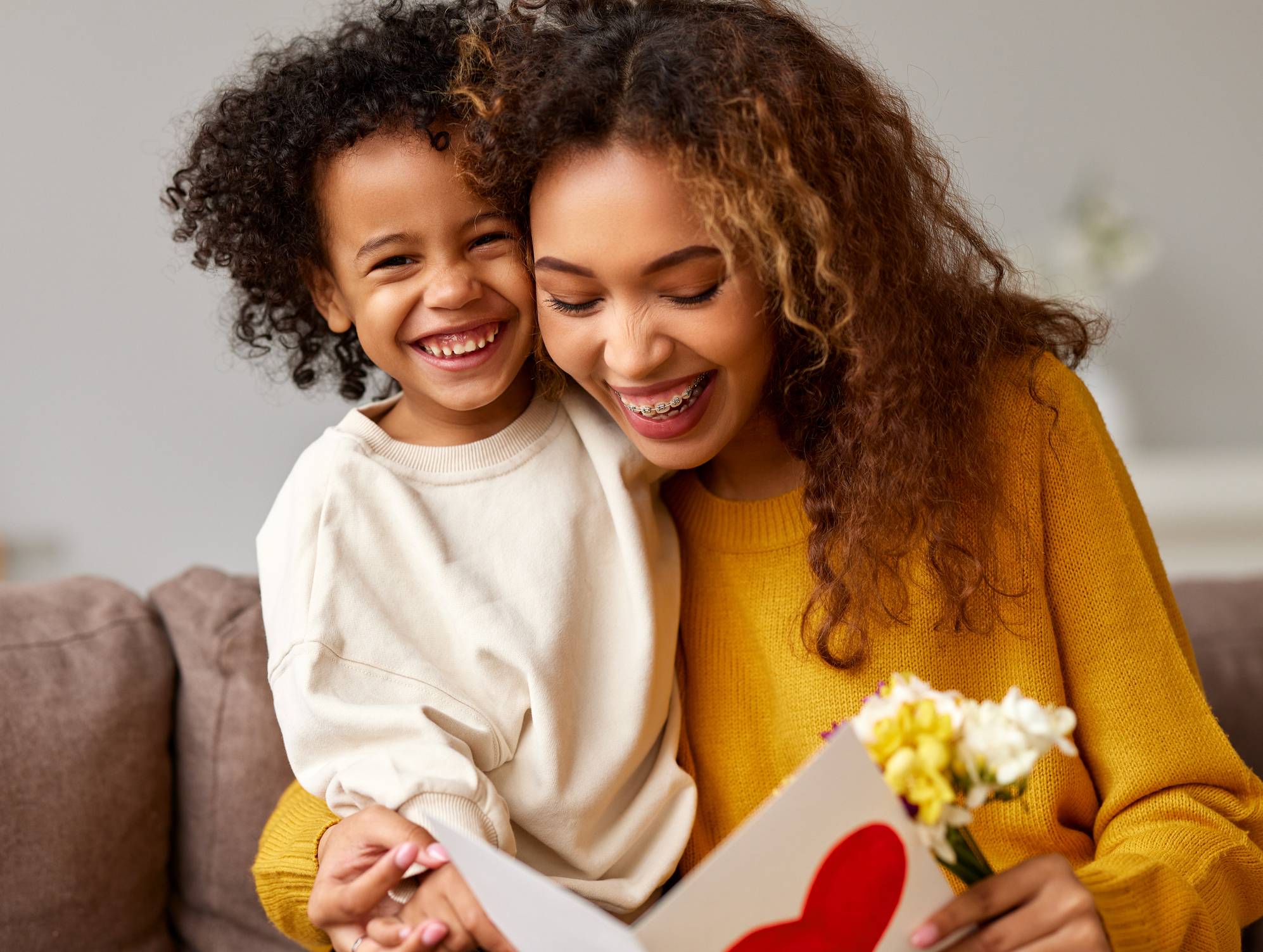 Young mixed race woman getting congratulations from son on Mothe Young mixed race woman getting congratulations from son on Mothe